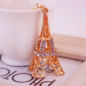 Porte-clés Tour Eiffel doré avec strass scintillants sur un fond blanc minimaliste