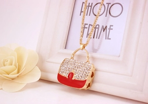Detailaufnahme der Handtaschen-Halskette mit rotem Emaille, Kristallen und goldener Kette