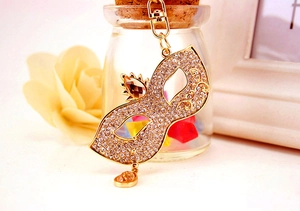 Macro shot of gold Venetian mask keychain with sparkling rhinestones and amber gemstone detail
