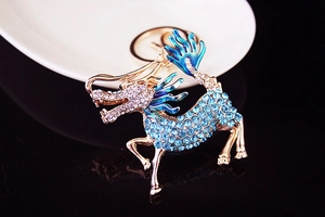 Macro view of blue rhinestone encrusted kylin keychain with gold metal plating
