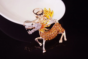 Macro view of a gold kylin keychain featuring amber rhinestones and a spring clasp