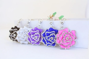 Close-up of five colorful enamel rose keychains with sparkling rhinestone accents