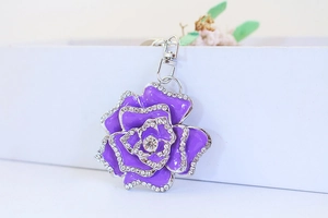 Close-up of purple enamel rose keychain with sparkling white rhinestones on silver metal hook