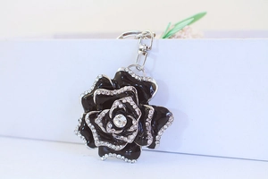 Detail of rose keychain with black enamel petals and sparkling rhinestone borders