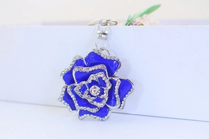 Close-up of deep blue rose keychain with silver metal petals and sparkling rhinestones