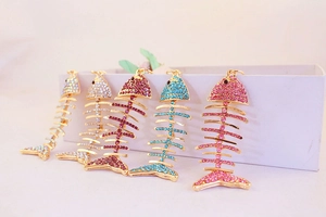 Vue détaillée de cinq porte-clés arêtes de poisson en cristal avec strass en couleurs