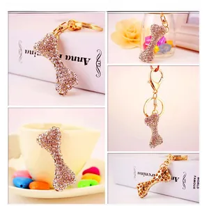 Macro detail of bone shaped keychain with pink rhinestones and gold lobster clasp