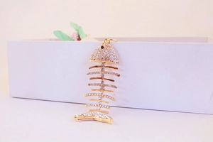 Détail du pendentif porte-clés arête de poisson doré avec des strass étincelants
