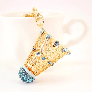 Porte-clés de badminton doré avec strass bleus sur fond de tasse en céramique