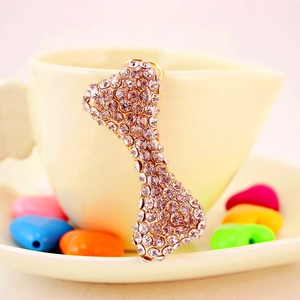 Sparkling rhinestone bone keychain in gold alloy finish on a white cup edge