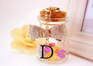 Vue macro du porte-clés à nœud en strass avec pendentif lettre D et décorations élégantes