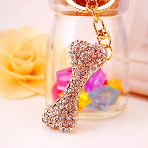 Sparkling bone-shaped keychain with crystal rhinestones on golden metal base
