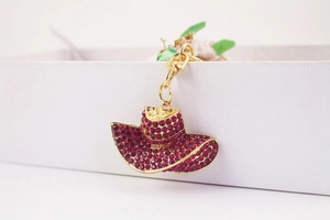 Detail view of rose red rhinestone sun hat keychain accessory with golden alloy clip
