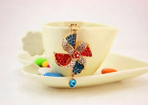 Detailed macro view of colorful rhinestone windmill pendant keychain with gold plating
