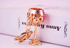 Macro detail of wine glass keychain with sparkling pink rhinestones and gold metal finish