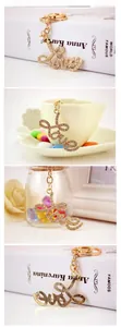Detail of a golden Love letter keychain with sparkling rhinestones in various settings