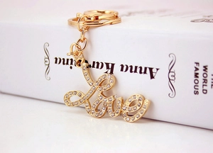 Macro shot of gold-plated Love letter keychain with sparkling crystals on book