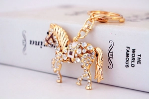 Détail macro d'un porte-clés cheval doré orné de cristaux et de strass scintillants