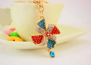 Macro shot of a sparkling crystal windmill keychain hanging on a white ceramic cup