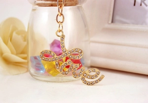 Macro shot of gold Love keychain with sparkling rhinestones on a decorative background