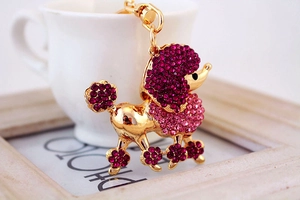 Détail du porte-clés caniche en cristal rose suspendu sur une tasse blanche avec une esthétique