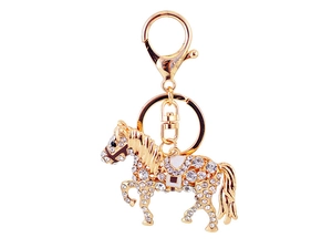 Détail d'un porte-clés cheval doré avec cristaux brillants et finition émaillée
