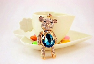 Detail showing crystal teddy bear keychain with large pear-shaped blue gemstone