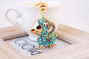 Détail d'un porte-clés chèvre avec strass bleus et finition en métal doré