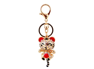 Détail d'un porte-clés tigre doré orné de strass brillants et de petites touches de rouge vif