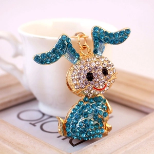 Cartoon bunny keychain with sparkling blue and white rhinestones on golden metal base