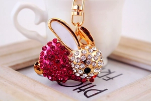 Nahaufnahme von rosa-weißen Strass-Hasen-Schlüsselanhänger mit goldenem Metallboden und Glasur