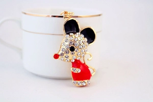 Detail of cartoon mouse keychain with gold metal, sparkling rhinestones and red enamel