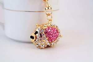 Macro view of crystal piggy keychain with pink heart detail and golden lobster clasp
