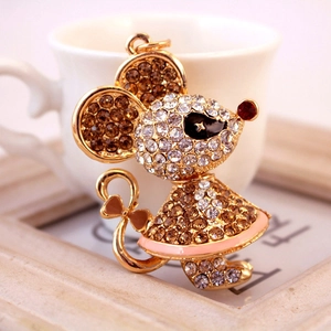 Sparkling rhinestone mouse keychain with bowknot detail on warm vintage background