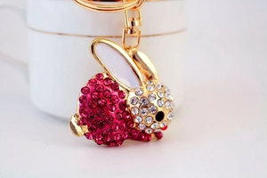 Nahaufnahme von rosa und weißem Strass-Hasen-Schlüsselanhänger mit goldener Karabiner-Verschluss