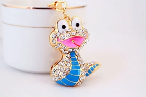 Vue macro d'un porte-clés serpent doré avec émail bleu et strass scintillants