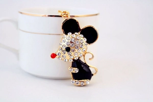 Detailed close-up of a golden mouse keychain with white rhinestones and black enamel finish