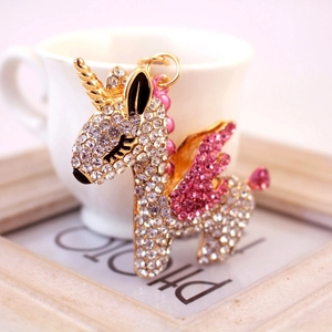 Portachiavi unicorno scintillante con corno dorato e ali di strass rosa su bianco