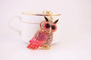 Detail of cute rhinestone owl keychain with pink crystals and gold metal hooks