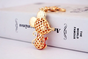 Detail of a gold mouse keychain with heart hollow patterns and sparkling rhinestones