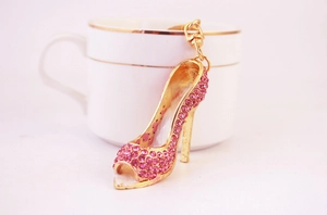 Dettaglio di un portachiavi a scarpa col tacco alto con cristalli rosa e oro