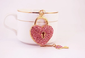 Vue détaillée du cadenas coeur et clé en strass rose avec placage en métal doré