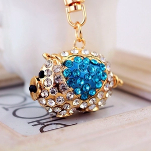 Sparkling blue and white rhinestone pig keychain with golden alloy finish and black accents