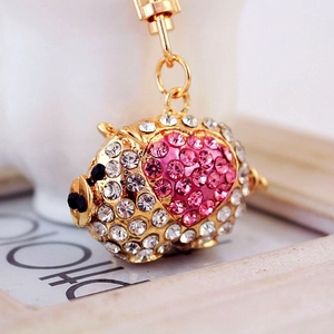 Gold pig keychain with white rhinestones and pink heart detail on a white background