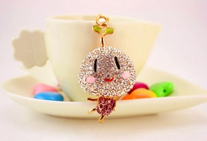 Gros plan du porte-clés germe doré mignon avec strass violets et roses brillants