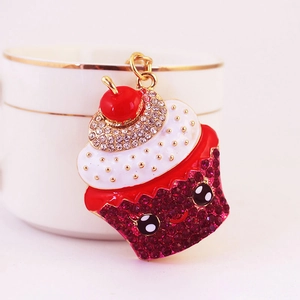 Cute pink cupcake keychain with rhinestones and cherry on top in a sweet setting
