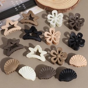 Matte star and flower hair claw clips set in earthy tones on wooden background