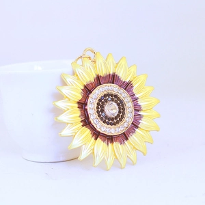 Chic sunflower keychain pendant with yellow petals and rhinestones near a white cup