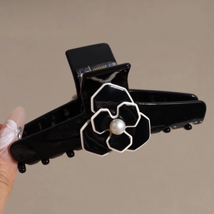 Elegant black camellia hair claw clip with pearl center and glossy finish for women