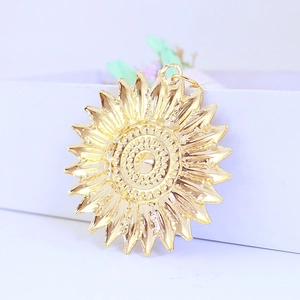 Golden metal sunflower keychain pendant with textured petals on a clean white background